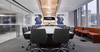 企业办公楼空间的连接感是通过编织在空间中的木质元素和灯具创造的
