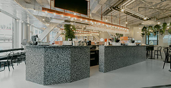 办公楼装修：餐厅的水磨石吧台独特的造型和配色赋予空间丰富的层次感