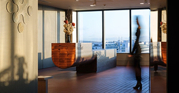 办公楼设计装修：深色纹理木材、黄铜网和厚重的窗帘扭曲了隐私和内部功能